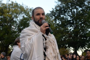Rabbi Yosef with a microphone at a vigil.